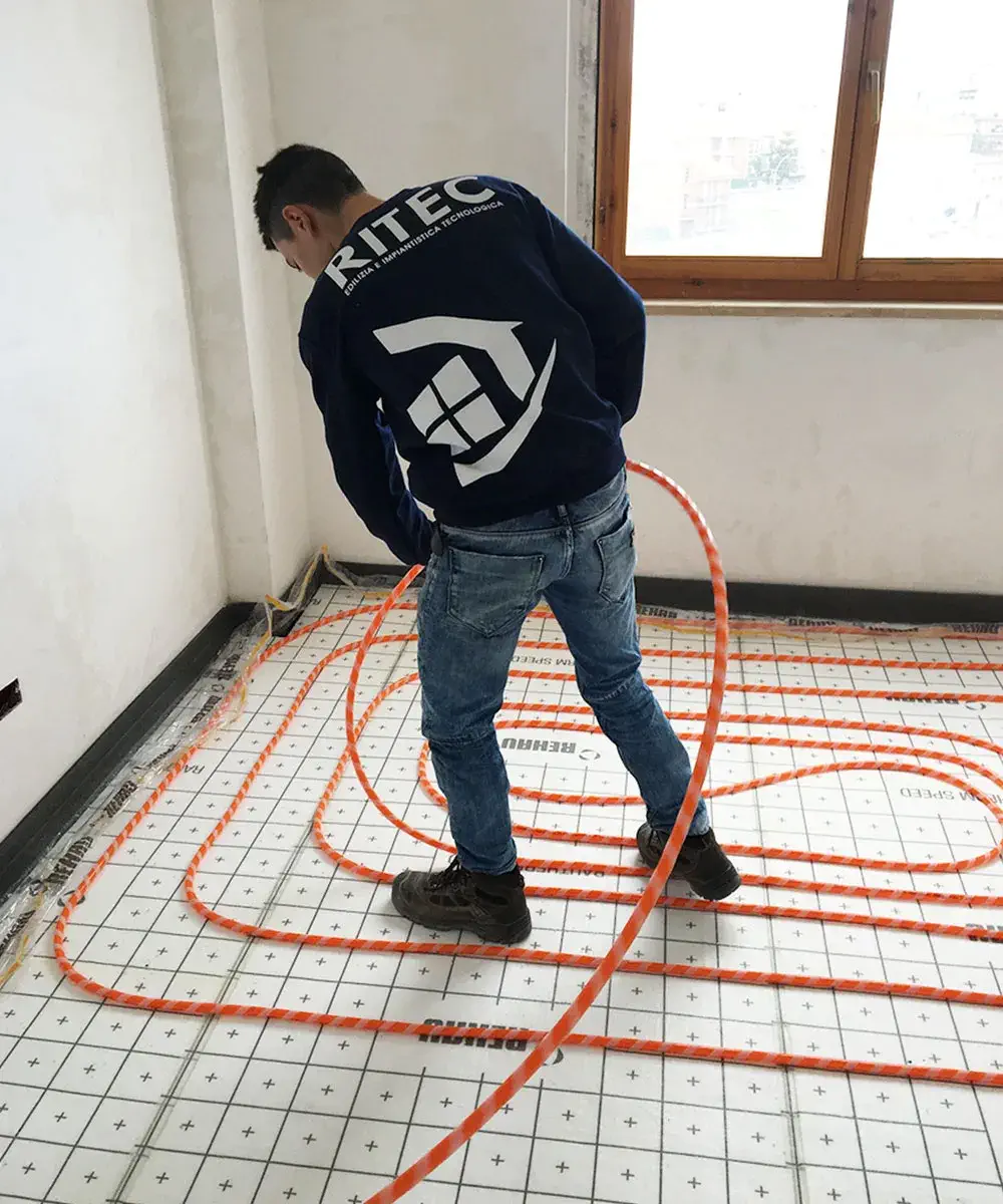 Ragazzo del team ritec che installa un impianto radiante a pavimento in un abitazione di aprilia