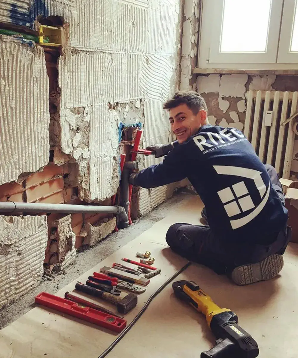 Giovane ragazzo sorridente del ritec team che installa un impianto sanitario