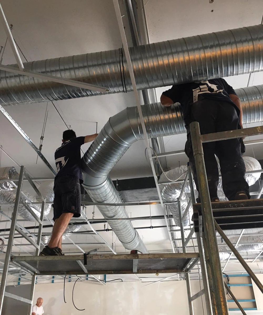 Due ragazzi del team Ritec che installano un impianto di ventilazione meccanica controllata (VMC) a Latina